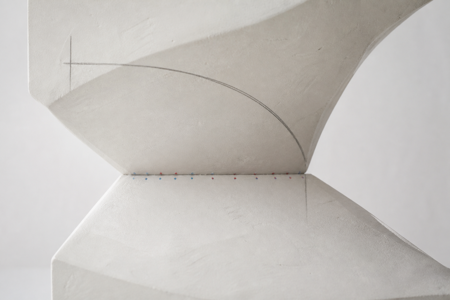 Abstract upper and lower plaster planes approaching alignment on a pale lab bench